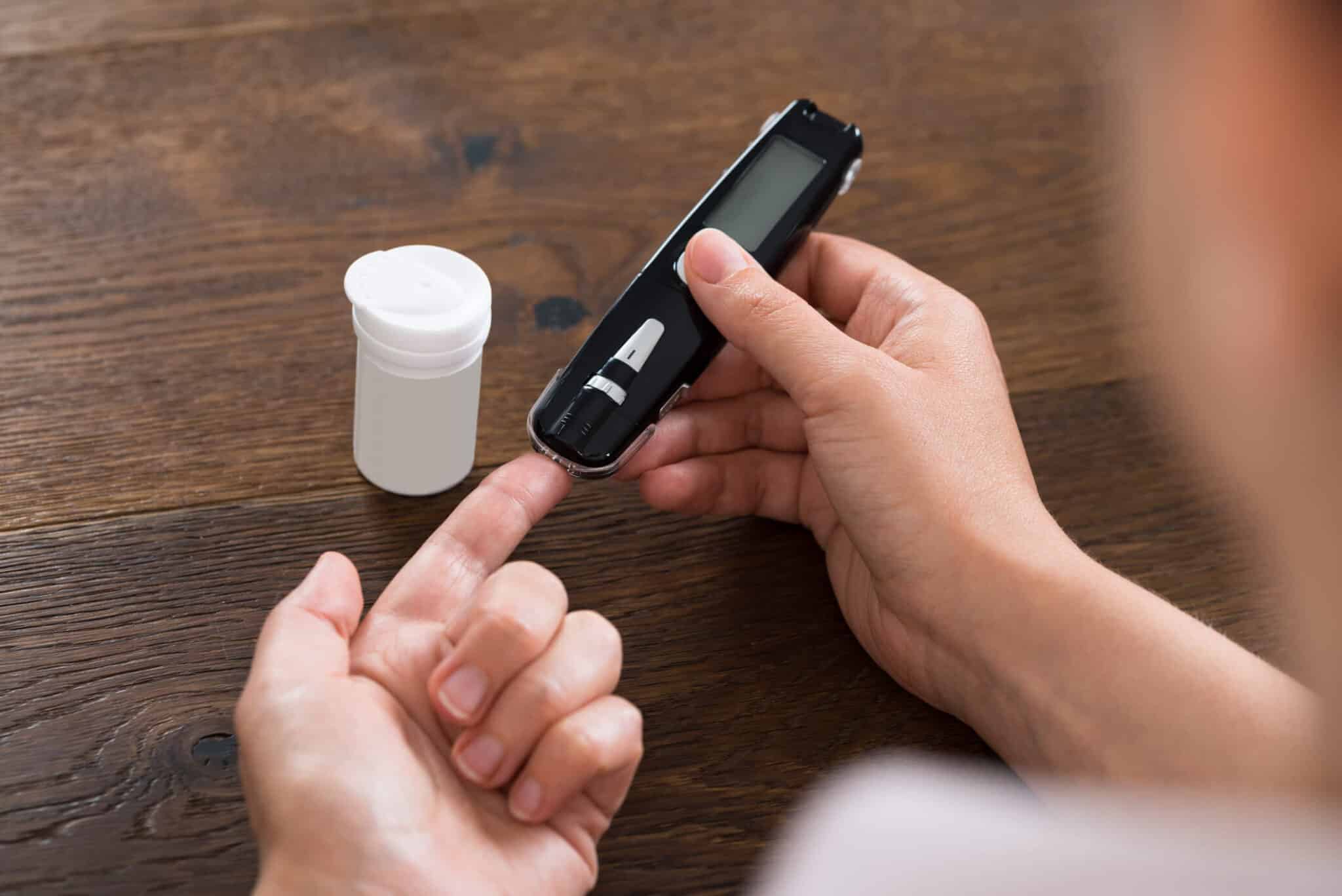 A blood glucose monitor and diabetic test strips arranged on a table at More Cash for Test Strips in Carson California